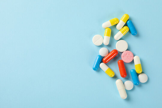 Different pills on blue background, space for text
