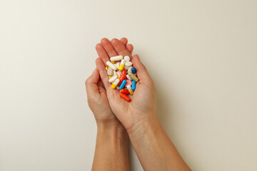 Female hands hold different pills on white background