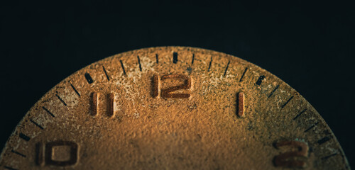 Vintage wall clock on a dark background. Selective focus. Vintage light toning. Grunge style backdrop