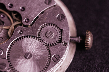 Old clockwork mechanism in close-up. Selective focus on macro details. Light vintage toning. Grunge style backdrop