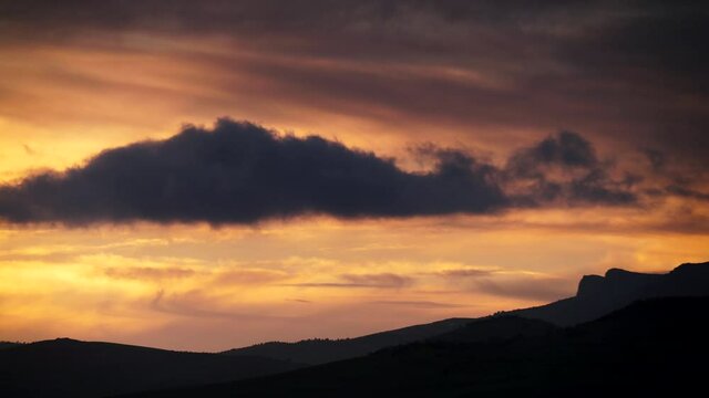 Skyscape. Clouds moving over hills at sunset time. Spain, Andalusia. Time lapse