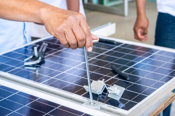 The technician's hand was holding the solar cell equipment to install the solar panel.