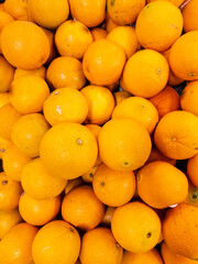 Fresh orange arrangement for background. Piles of fresh fruit to create designs about agriculture, food, nature, & healthy living.