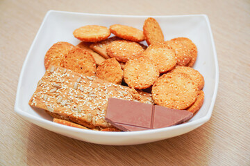 Cookies and a dark chocolate bar on a white plate