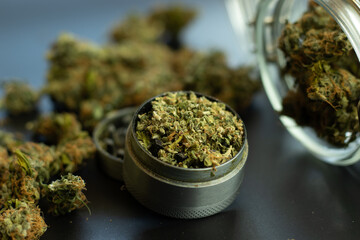 Legal use of cannabis for medical purposes. Marijuana bud background, weed in grinder and jar close...