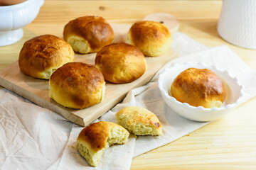 Fresh bun, kitchen utensils and eggs on wooden background, homemade bakery