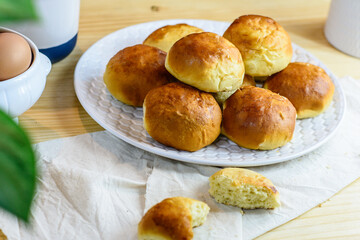Fresh bun, kitchen utensils and eggs on wooden background, homemade bakery