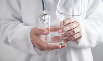Medical doctor holding a glass of water.