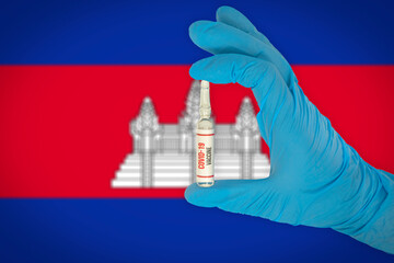 New coronavirus vaccine with the flag of Cambodia in the background. Cambodia medical research and vaccine development center. Doctor holding coronavirus vaccine in his hand.