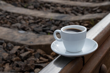 a cup of coffee on the train tracks