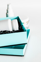 White plastic pill bottle in turquoise and black gift box.