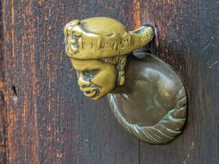 A bronze door handle on an old wooden door - Venice, Veneto, Italy