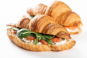 french croissant with salmon, cream cheese and spinach on a white background, selective focus