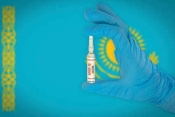 New coronavirus vaccine with the flag of Kazakhstan in the background. Kazakhstan medical research and vaccine development center. Doctor holding coronavirus vaccine in his hand.