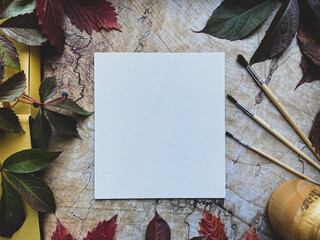 White canvas surrounded by autumn leaves