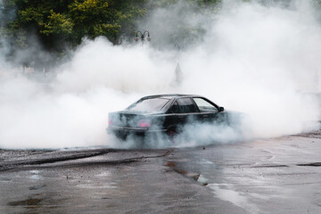 Drift car wheel drifting on the track with smoking tires. scraping the asphalt while racing