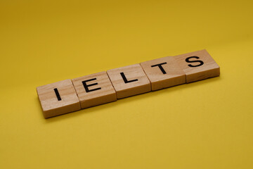 IELTS Word Written In Wooden Cube With Yellow Background