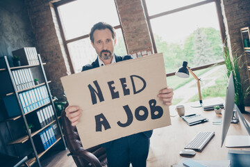 Not boss anymore. Photo of moody despair sad laid off dismissed worker mature guy hold placard poster search new job last work day workplace fired bad mood modern office indoors