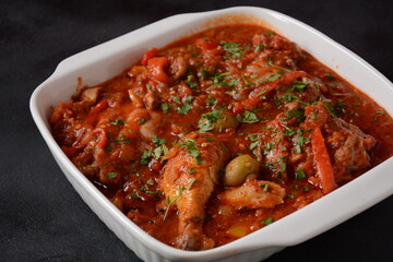 Chicken cacciatore with bell peppers, tomatoes, black olives. Italian food