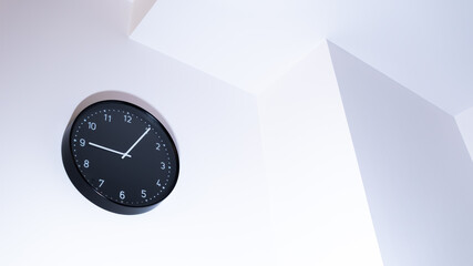 A black clock on a white wall