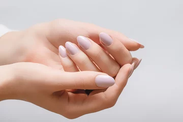 Foto op Plexiglas Vrouwelijke handen met roze nagelontwerp. Roze glitter nagellak manicure op witte achtergrond © devmarya