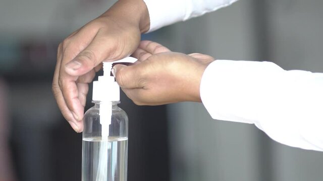 Coronavirus hand sanitizer sanitiser gel for clean hands hygiene corona virus spread prevention. Man using alcohol rub alternative to washing hands. REAL TIME video. 