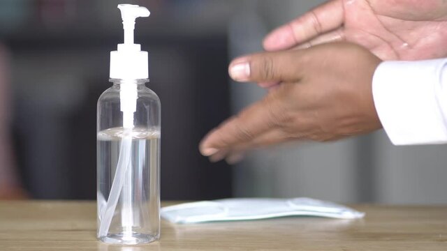 Coronavirus hand sanitizer sanitiser gel for clean hands hygiene corona virus spread prevention. Man using alcohol rub alternative to washing hands. REAL TIME video. 