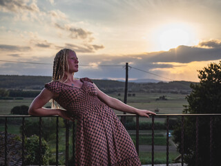 albino young woman in a dress in a sunset with nice view