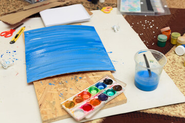 watercolor paints and paper closeup for drawing, artistic creation at home, workspace for make creative artwork
