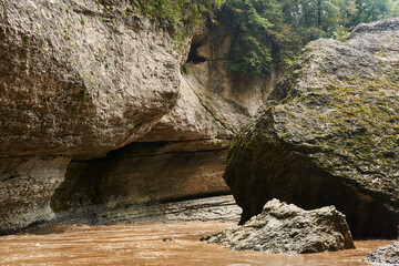 mountain gorge with muddy river during flooding