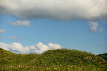 Wonderful mountain landscape. Flower glades, green mountains and beautiful clouds