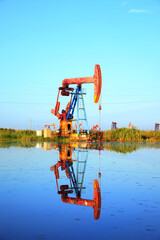 Oil pump under the blue sky, beam pumping unit in the oil field