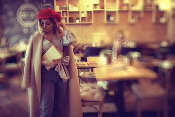 girl sitting in a cafe at a table / beautiful young model posing with a bunch of flowers, happy adult girlfriend