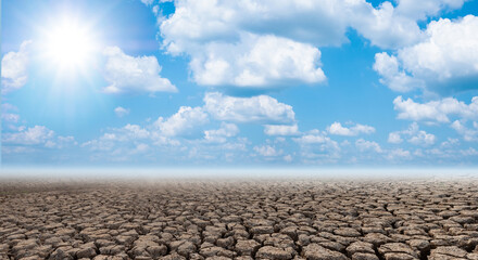 Cracked and dry soil in arid areas landscape with blue sky sun and cloud