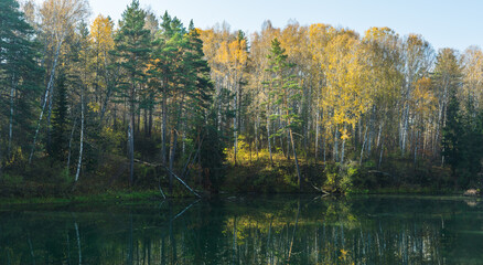Autumn morning on the lake in the middle of forest. Autumn landscape.