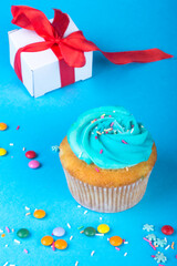 Cupcake with present gift on blue