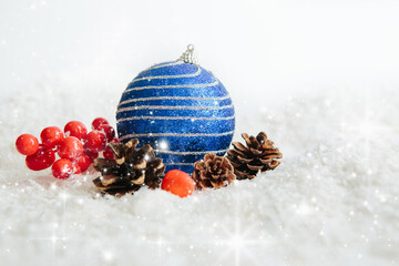 Blue Christmas ball on snow Beautiful Christmas bauble decorations lie on the white fluffy snow....