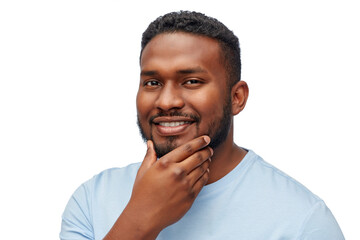people, grooming and shaving concept - portrait of happy smiling young african american man touching his beard over white background