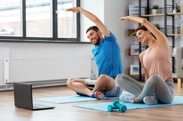 Gordijnen sport, fitness, lifestyle and people concept - smiling man and woman with laptop computer exercising at home © Syda Productions