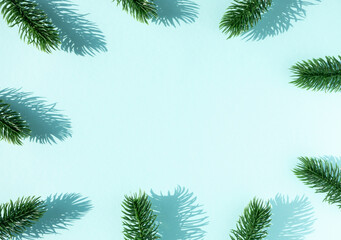 Frame of green fir branches on blue background