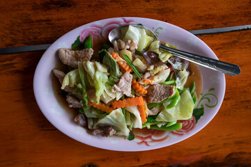 stir-fried mixed vegetable with pork on wooden table