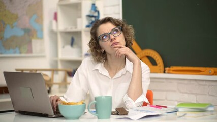 Portrait of creative young smiling female Student in glasses. World teachers day. Young teacher in glasses over green chalkboard.