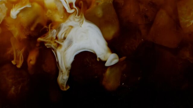 Ice Coffee Mixing with Pouring Milk Cream. Filmed on High Speed Cinema Camera.