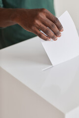 Close-up of African man putting the ballot into the ballot box during election