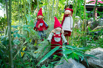 Beatiful toy doll puppets in green and treeed garden.