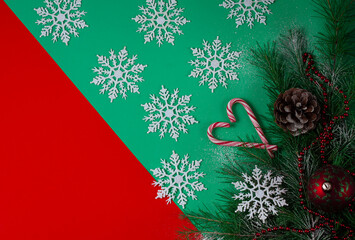 christmas tree and decorations, top view, on a green  and red background, snowflakes and lollipop , cane light in claus