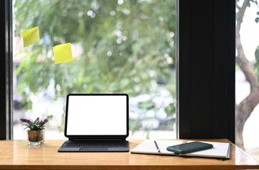 Fototapeta premium Contemporary workspace with empty screen tablet computer on wooden table.