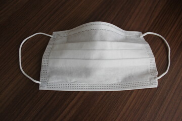 Surgical mask with rubber ear straps. Typical 3-ply surgical mask to cover the mouth and nose. Procedure mask from bacteria. Protection concept.
