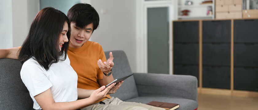 Happy couple with tablet spending time together at home.
