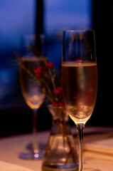 夜のロマンチックなフレンチレストランでのディナータイム　シャンパングラスと花　テーブルセッティング